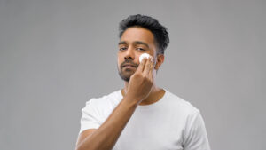 man applying toner on face