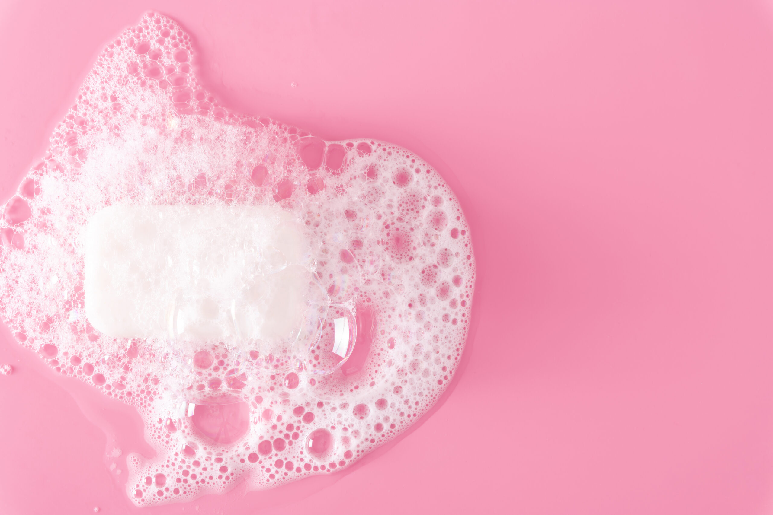 White,Soap,Bar,And,Foam,On,Pastel,Pink,Background.,Flat